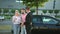 Seller sells the car to happy young couple. Buyer sign a vehicle purchase