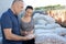 Seller showing stone sample to female client in gardening store