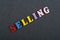 SELLING word on black board background composed from colorful abc alphabet block wooden letters, copy space for ad text