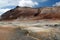 Seltun / Krysuvik KrÃ½suvÃ­k: Road through red hills leading to yellow and white geothermal valley