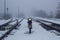 Semaphore on the railway in winter, glowing yellow. Gloomy scene