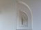 Semi arched window openings in stucco finished white walls in diminishing perspective