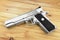 Semi-automatic handgun on grey wooden background, .45 pistol.