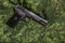 Semi-automatic pistol on pixel camouflage background