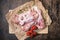 Semi-finished poultry products. Raw turkey wing surrounded by vegetables, spices and herbs on a dark wooden background