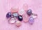 Semi-precious stones of different colors in processed form. Amethyst crystals, rose quartz and rock crystal on pink lace