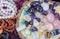 Semi-precious stones on the round saw cut tree trunk. Amethyst, rose quartz, agate, tiger\\\'s eye pendants