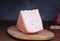 Semi-solid milk cheese on a wooden board with crackerc and pear
