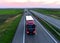 Semi-trailer truck DAF driving along highway on sunset background. Truck convoy or caravan of trucks delivery goods by roads.