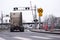 Semi truck tractor moving by railroad crossing