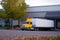 Semi Truck yellow cab and trailer parked at dock for unloading