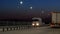 Semi trucks on the highway carrying freight container. Lanterns at night along the road