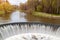 semicircular dam and waterfall with spring green foliage nature forest river hydro power station