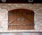 Semicircular wooden gate with wrought door handles and wrought door hinges. Ancient beautiful brick building, architecture,