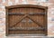 Semicircular wooden gate with wrought iron doorknobs in a brick building. Ancient architecture, close-up