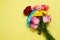 Send flowers online concept. Flower delivery for valentine and mother day. Bouquet of red pink roses isolated on yellow background