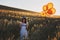 Sending a letter on the wind. Shot of a cute little girl attaching a letter to a bunch of balloons while standing in a