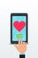 Sending love message using flat smartphone with pink heart icon on touch screen. Finger push send button.