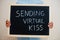 Sending virtual kiss. Coronavirus concept. Boy hold inscription on the board