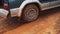 Sendrisoa, Madagascar - April 28, 2019:  4WD car pass slowly over holes in muddy ground, detail on rear wheel. Roads are in awful