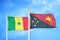 Senegal and Papua New Guinea two flags on flagpoles and blue cloudy sky