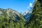 Senes - A lush green valley in Italian Dolomites. There are tall trees and high mountains around. The mountain slopes are rocky