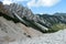 Senes - A lush green valley in Italian Dolomites. There are tall trees and high mountains around. The mountain slopes are rocky