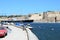 Senglea, Malta, July 2015. View of the fortifications of the capital of the island on the other side and the passing cargo ship.