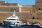 Senglea, Malta, July 2016. Fortified walls with entrance gates and a large yacht at the pier.