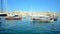 SENGLEA, MALTA - JUNE 19, 2018: Scenic luzzu boats, rocking on the gentle waves in Vittoriosa marina with a view on medieval Birgu