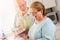 Senior Adult Couple Washing Dishes Together Inside Kitchen of Their House