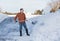 Senior adult man finishes digging out drive in snow