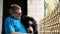 Senior adult man petting and hugging his Bernese Mountain Dog, while sitting on porch of house.
