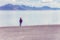 Senior adult woman stands in the Bonneville Salt Flat when it is flooded on a summer day