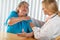 Senior Adult Woman Talking with Female Doctor About Sore Shoulder