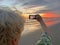 Senior adventure is ageless woman with a mobile phone take a photo of beautiful of sunset near sea beach. Summer vacation for