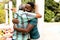 Senior African American man embracing with his son during a family lunch in the garden