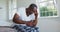 Senior african american man with headache sitting on bed holding head