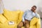 senior african american man sleeping on couch book and eyeglasses