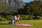 Senior african american woman kneeling on yoga mat on grass in stunning countryside