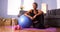 Senior African woman sitting on floor with exercise equipment