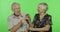 Senior aged man and woman sitting and talking together. Chroma key background