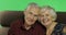 Senior aged man and woman sitting together on a sofa and smiles. Chroma key
