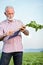 Senior agronomist or farmer measuring sugar beet roots with a ruler and writing data into questionnaire