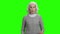 Senior allergic woman is sneezing on green screen.