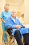 Senior as a patient in a wheelchair with caregiver