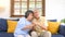 Senior asian couple comforting each other from depressed emotion while sitting on sofa at home living room, old retirement