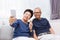 Senior Asian couple grandparents taking a selfie photo together at home.