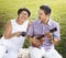 Senior Asian couple playing music in a park.