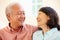 Senior Asian Couple Sitting On Sofa At Home Together